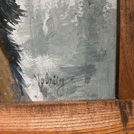 Close-up of a signature on a textured surface with a wooden frame.
