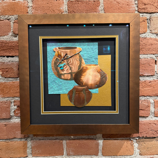 Framed artwork of three ceramic pots on a brick wall