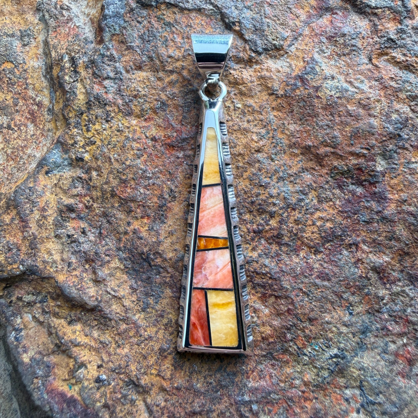 various orange stone pendant on a triangular pendant