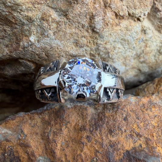 Silver ring with a large cubic zirconia on a rocky surface