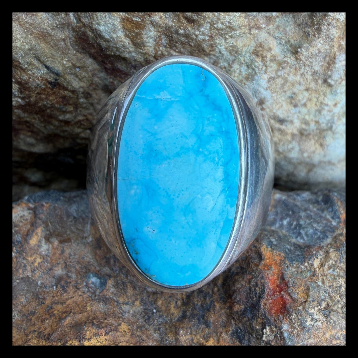 Turquoise stone ring on a rocky surface