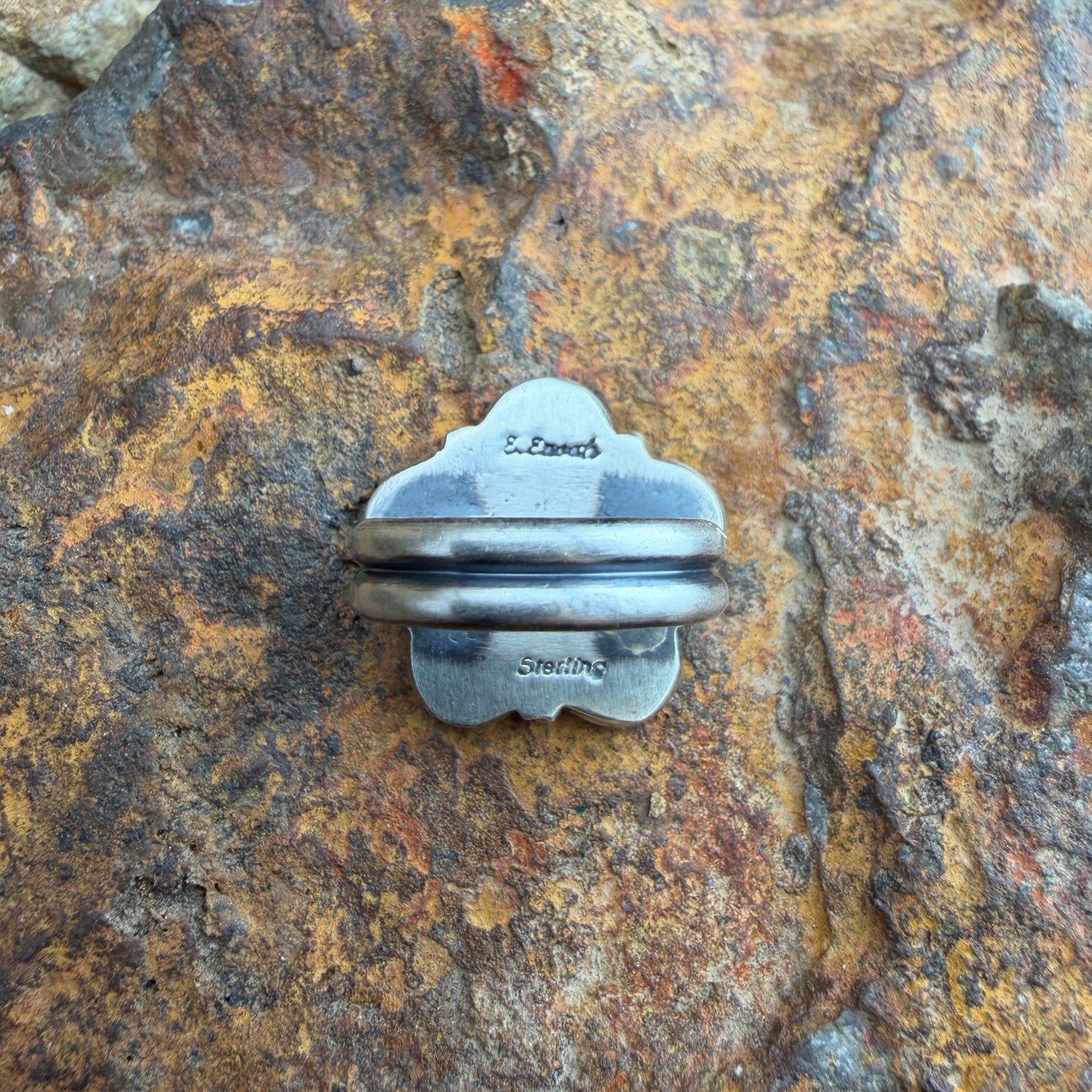 back of a silver ring with stamping.
"E. Enoah" and "sterling"