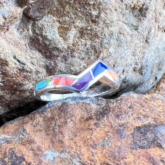 Multicolored inlay ring on a textured stone surface