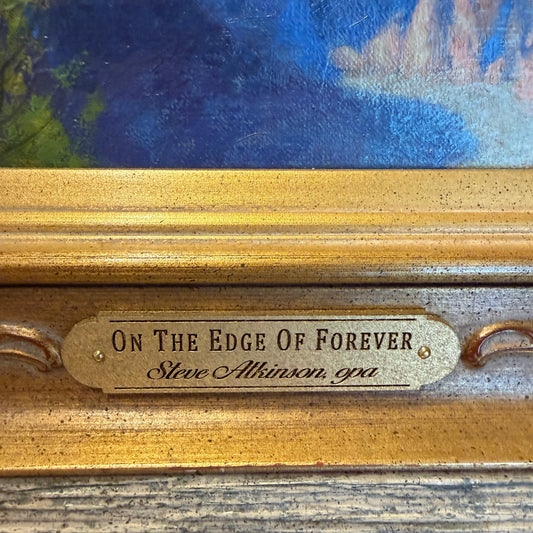 Gold plaque with text 'On The Edge Of Forever' and artist's name on a painting