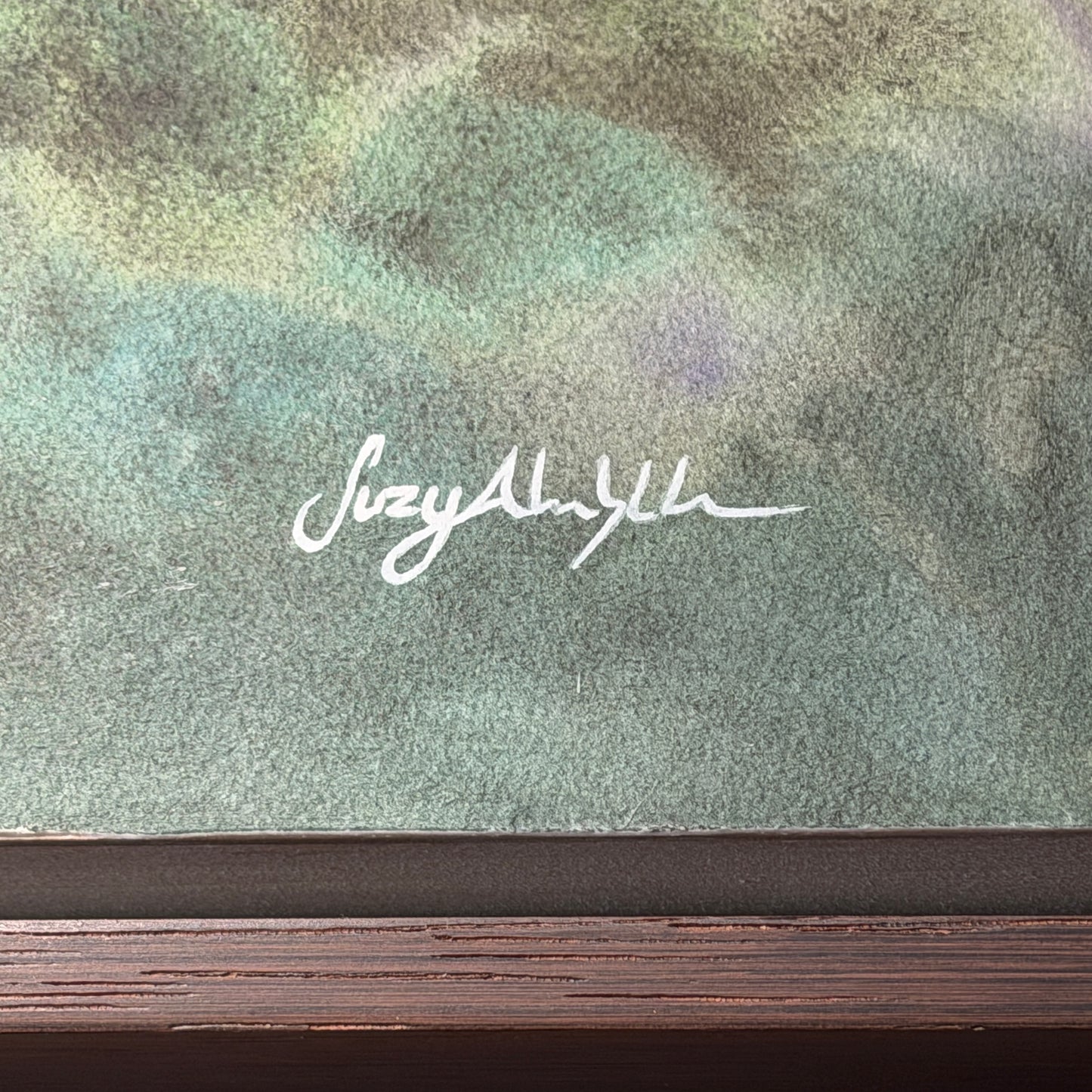Signature on a watercolor painting with a wooden frame