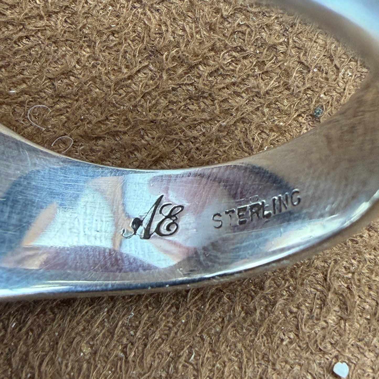 Close up of stamping on the inside of a ring. stamped "AE' and "STERLING"