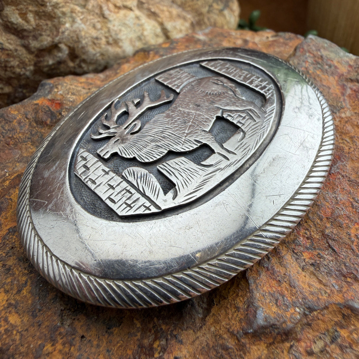 Silver belt buckle with deer emblem
