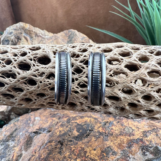 sterling silver half-hoop earrings featuring a deeply oxidized ribbed center band flanked by smooth, polished rims.