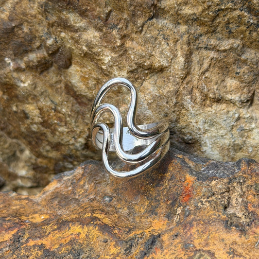 Angled view of Ray Coriz sterling silver smooth wave ring showing open spaces between the bands
