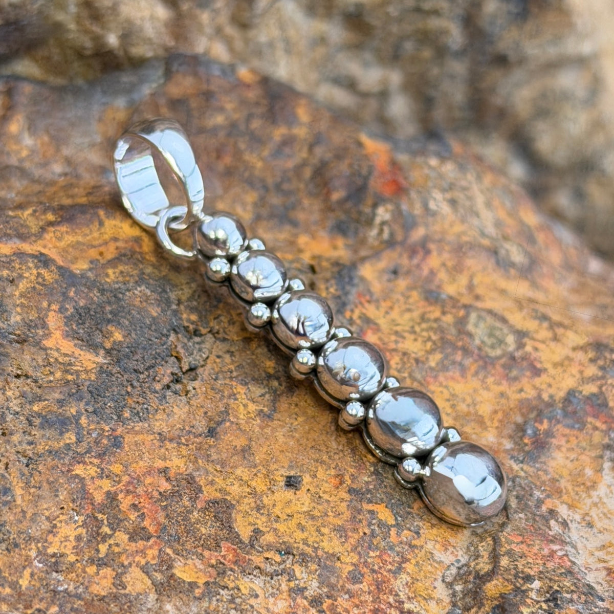 six sphere silver pendant showing Artie Yellowhorse hallmark and Sterling stamp