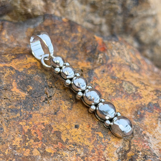 six sphere silver pendant showing Artie Yellowhorse hallmark and Sterling stamp