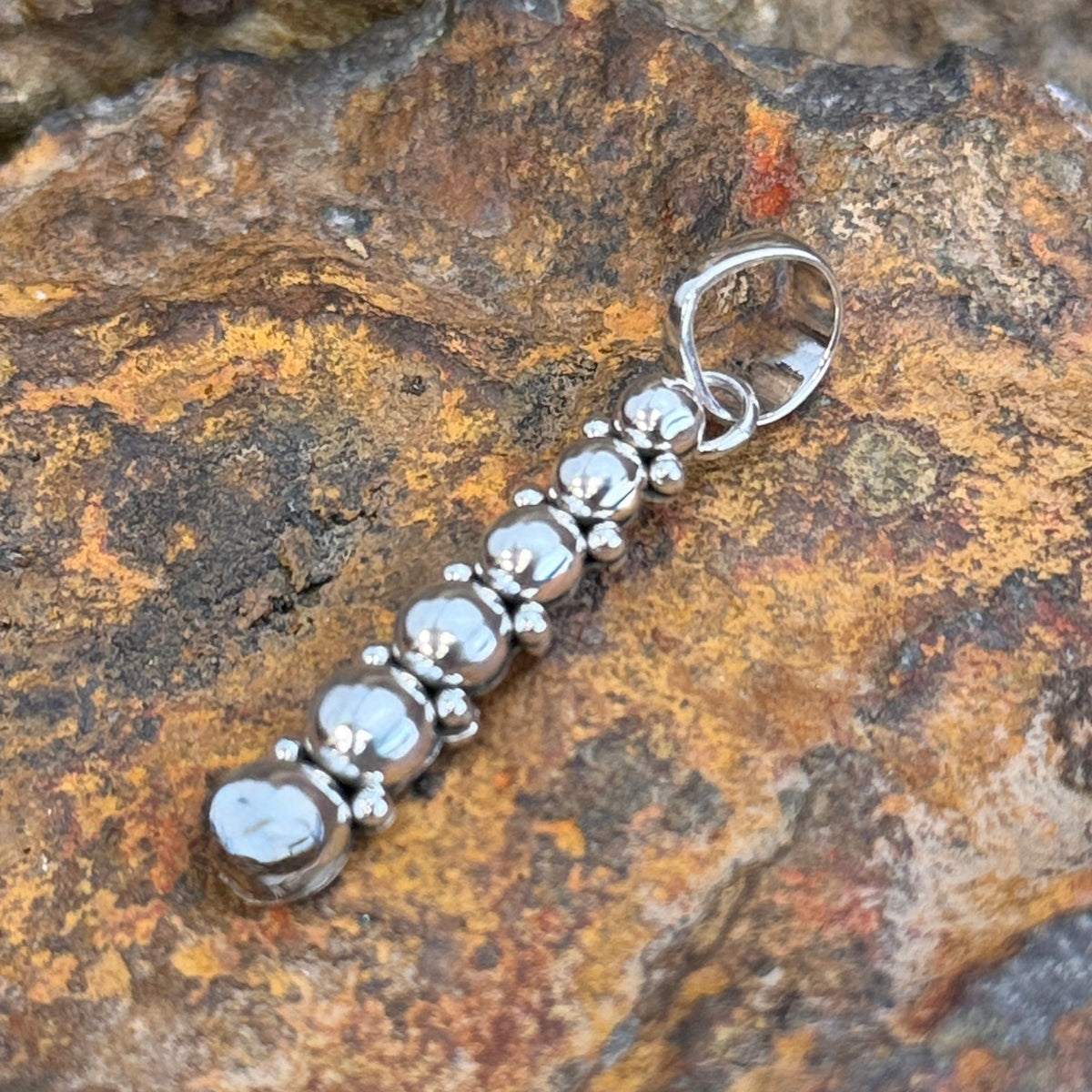 Graduated six sphere silver pendant with small bead accents and polished bale