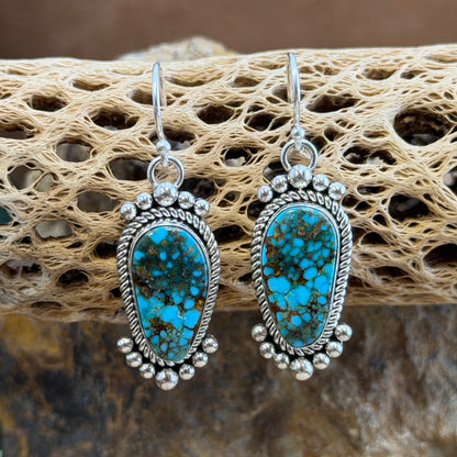 Kingman Turquoise Dangle Earrings by Artie Yellowhorse - front view on cholla cactus showing vivid spiderweb matrix and silver bead clusters