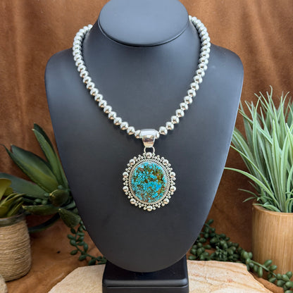 Kingman Turquoise Oval Pendant by Artie Yellowhorse - styled on Navajo pearl bead necklace, front view