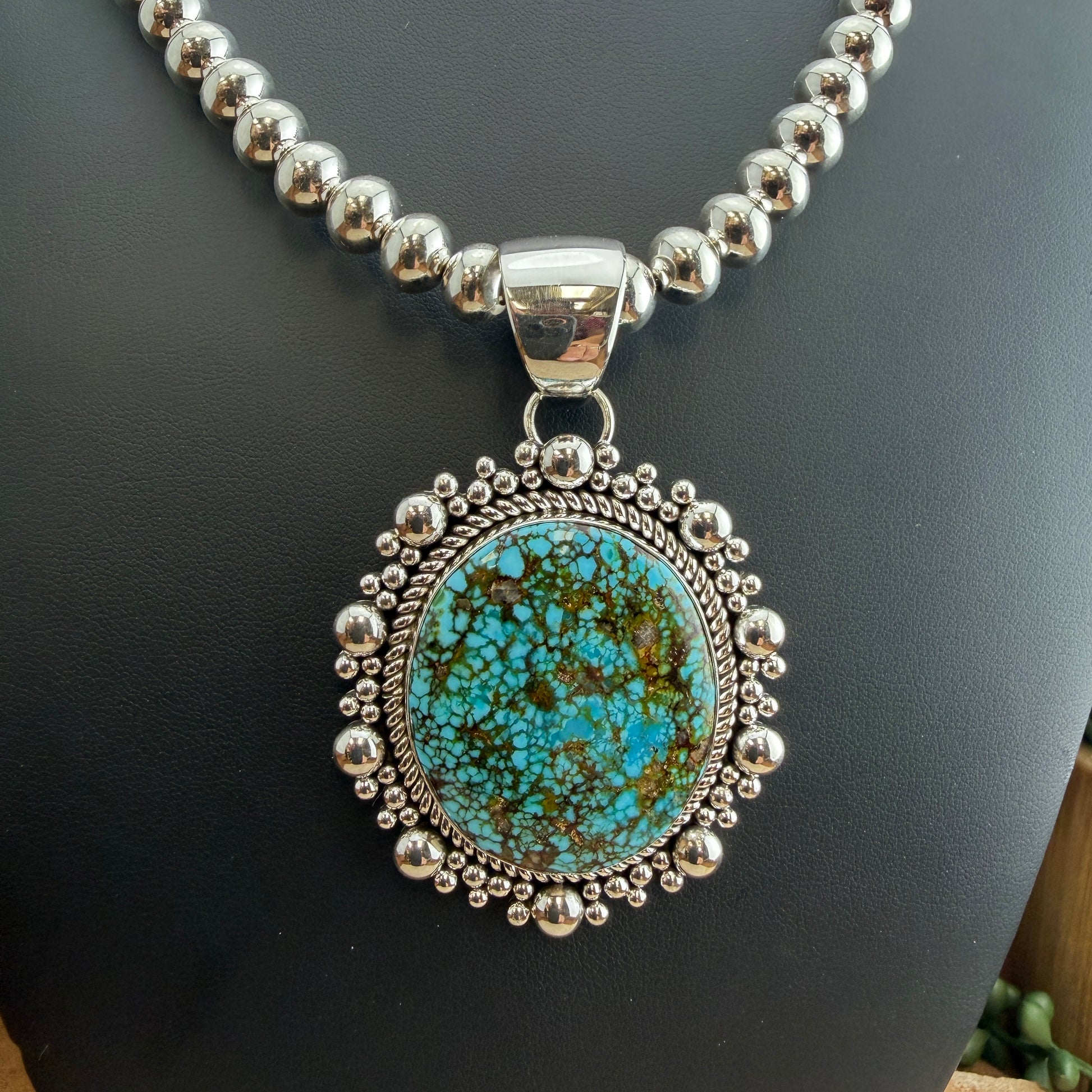 Kingman Turquoise Oval Pendant by Artie Yellowhorse - close-up styled on Navajo pearl necklace showing stone detail