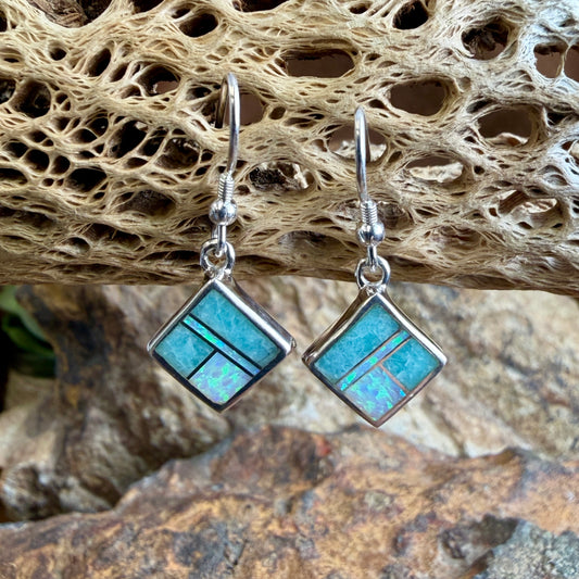 square earrings with opals and blue coloring hanging from cactus skeleton