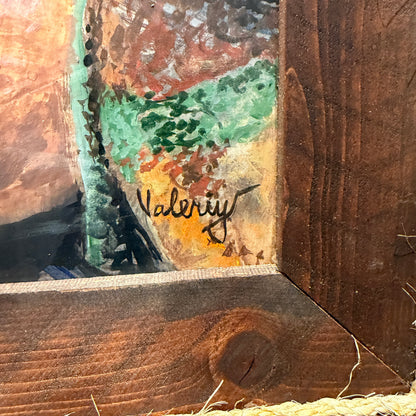 Artistic signature on a textured wooden surface with abstract colors.