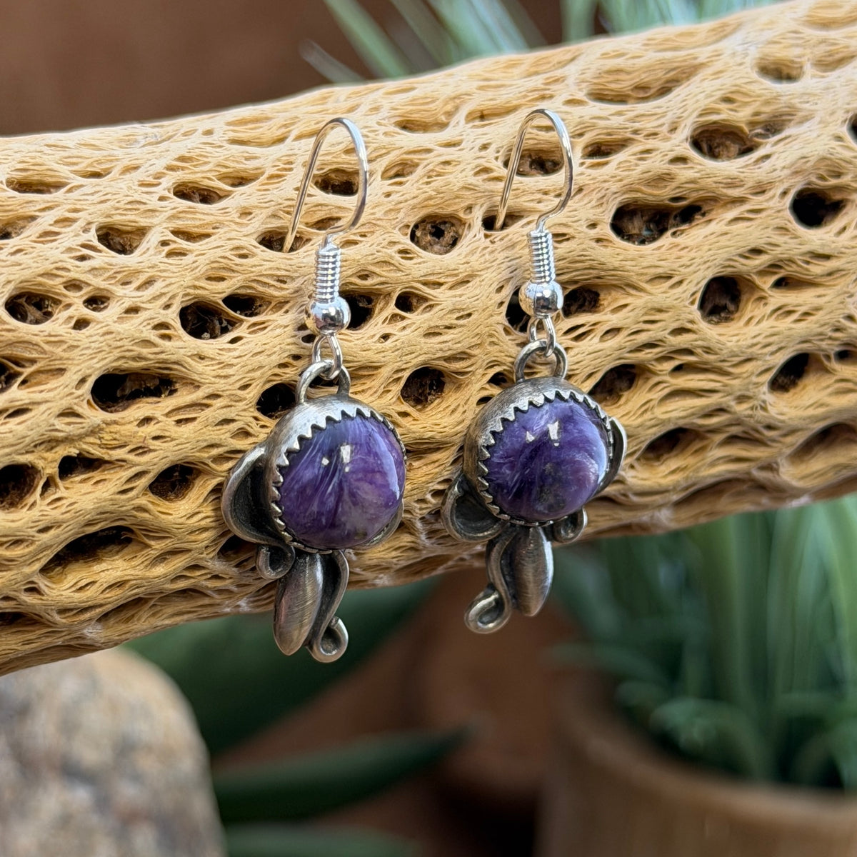 Angled view of charoite cabochons in scalloped sterling silver bezel settings