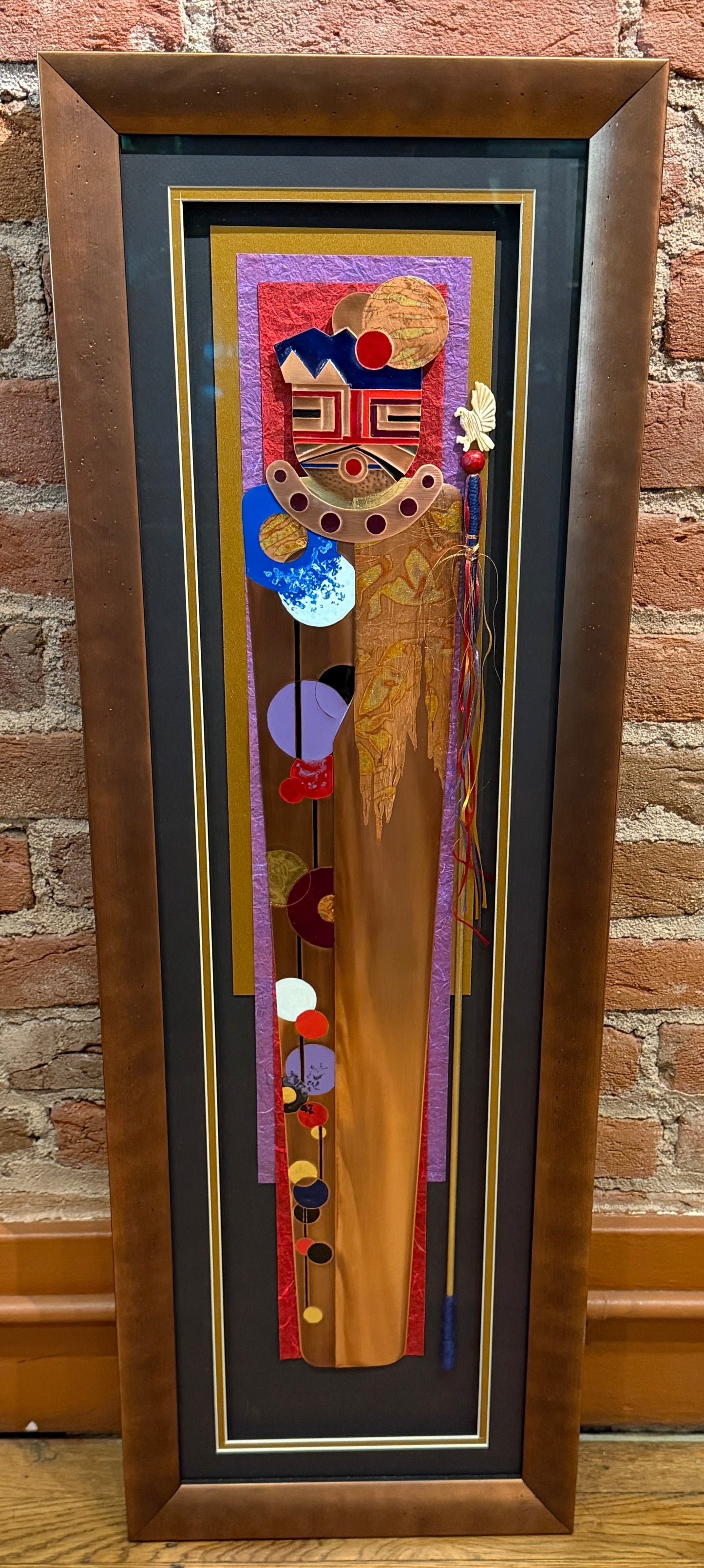 Framed artwork with abstract design on a brick wall background