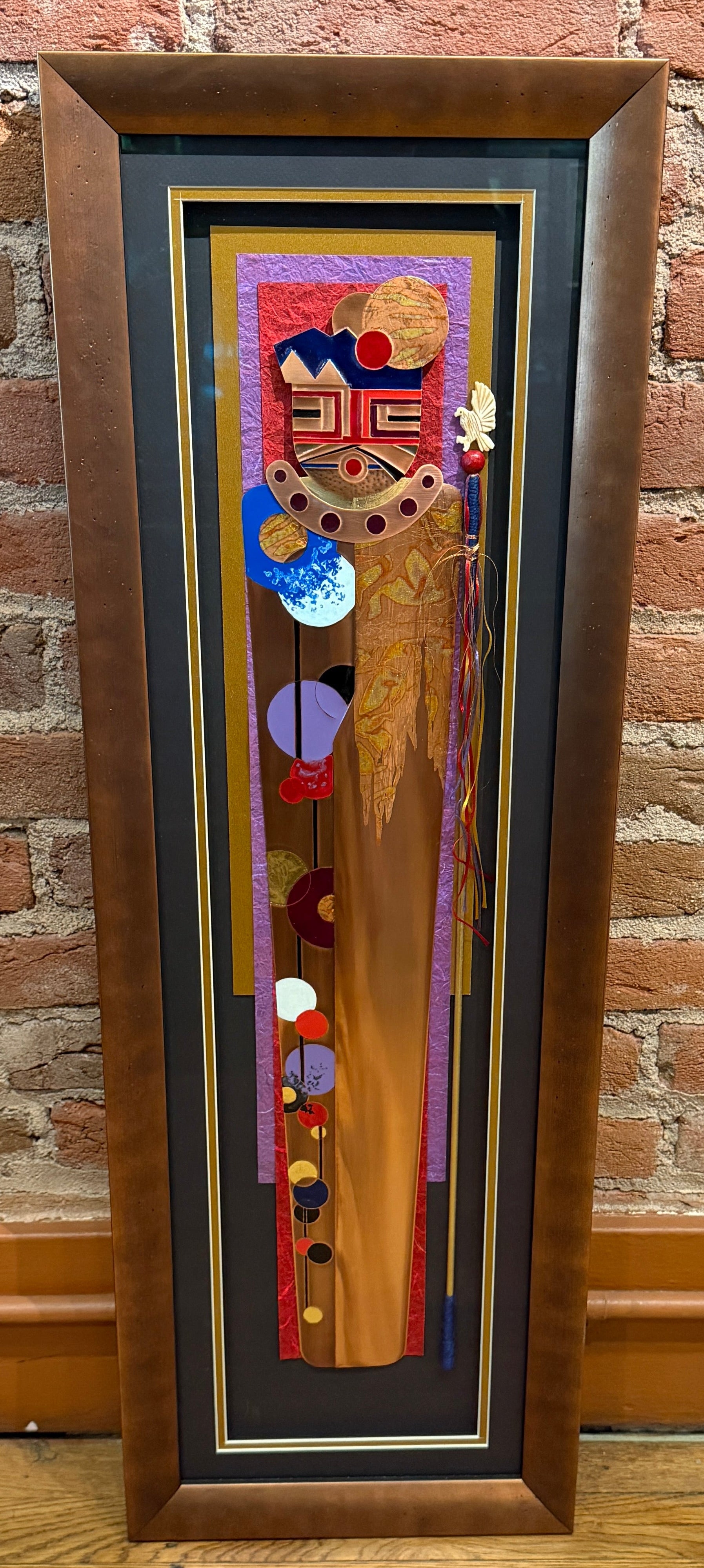 Framed artwork with abstract design on a brick wall background