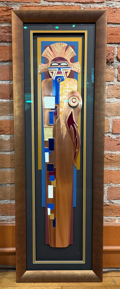 Decorative door with abstract design in a wooden frame against a brick wall.