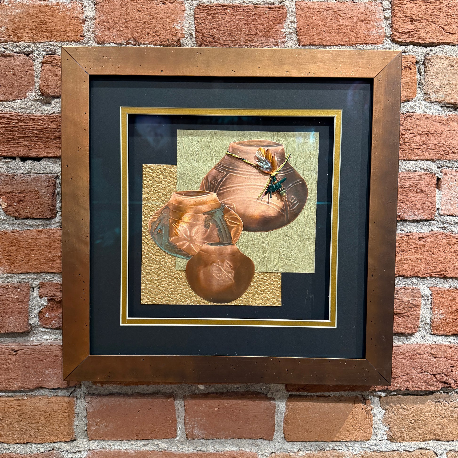 Framed artwork of ceramic pots on a brick wall