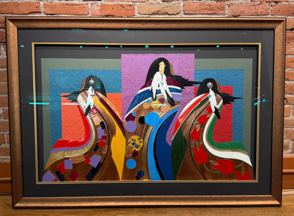 Framed abstract artwork with horses on a wooden surface and brick wall background
