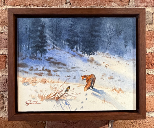 Framed painting of a fox in a snowy landscape on a brick wall.