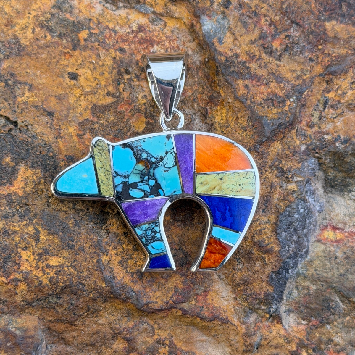 Bear shaped Sterling silver pendant with blue, green, orange, red, purple inlay with raised silver channels.