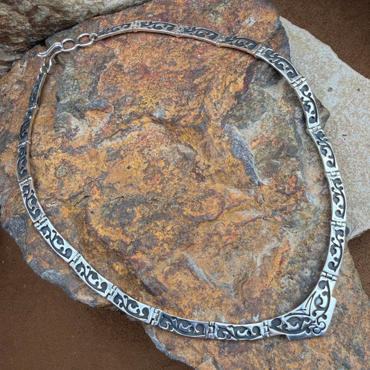 Silver necklace on a textured stone surface