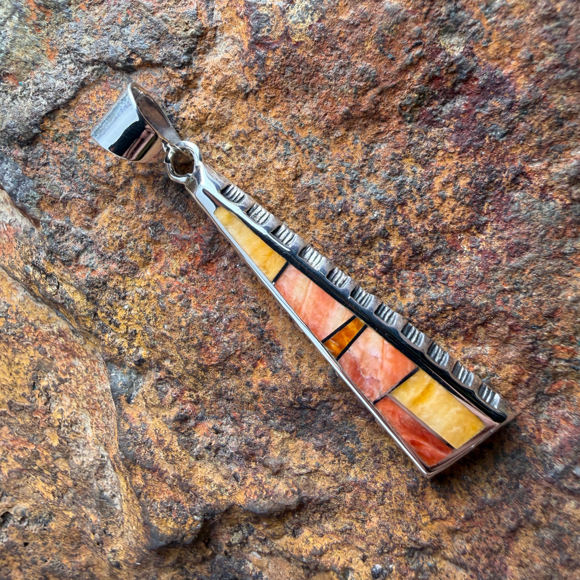 various orange stone pendant on a  triangular pendant