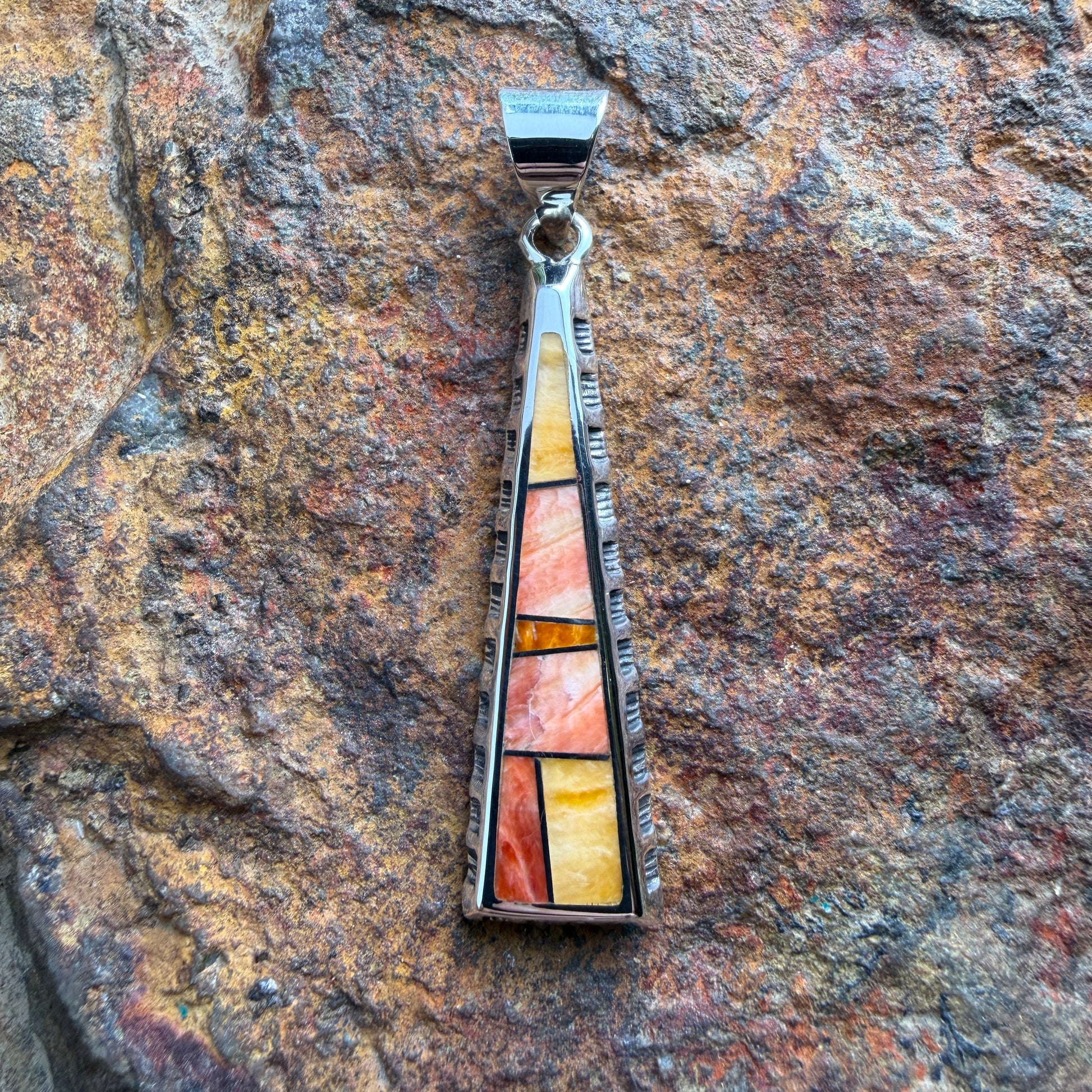 various orange stone pendant on a  triangular pendant