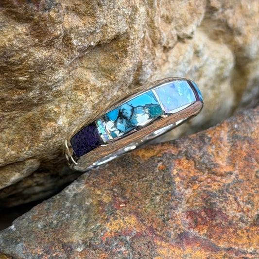 David Rosales Sterling Silver Ring with multicolor inlay. Inlaid with purple, turquoise and opal. it is resting in-between two rocks.