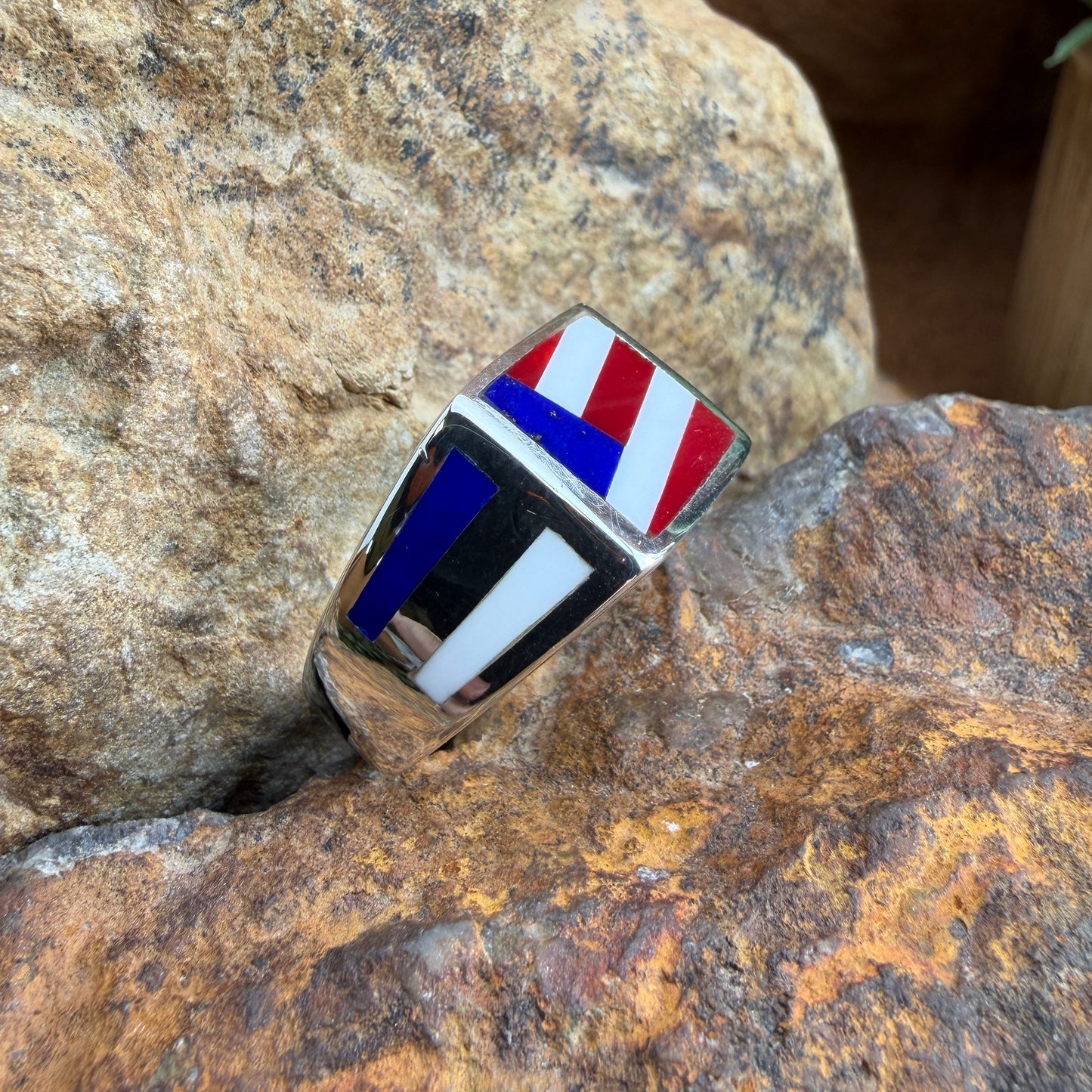 Ring with a flag design, placed on a rocky surface