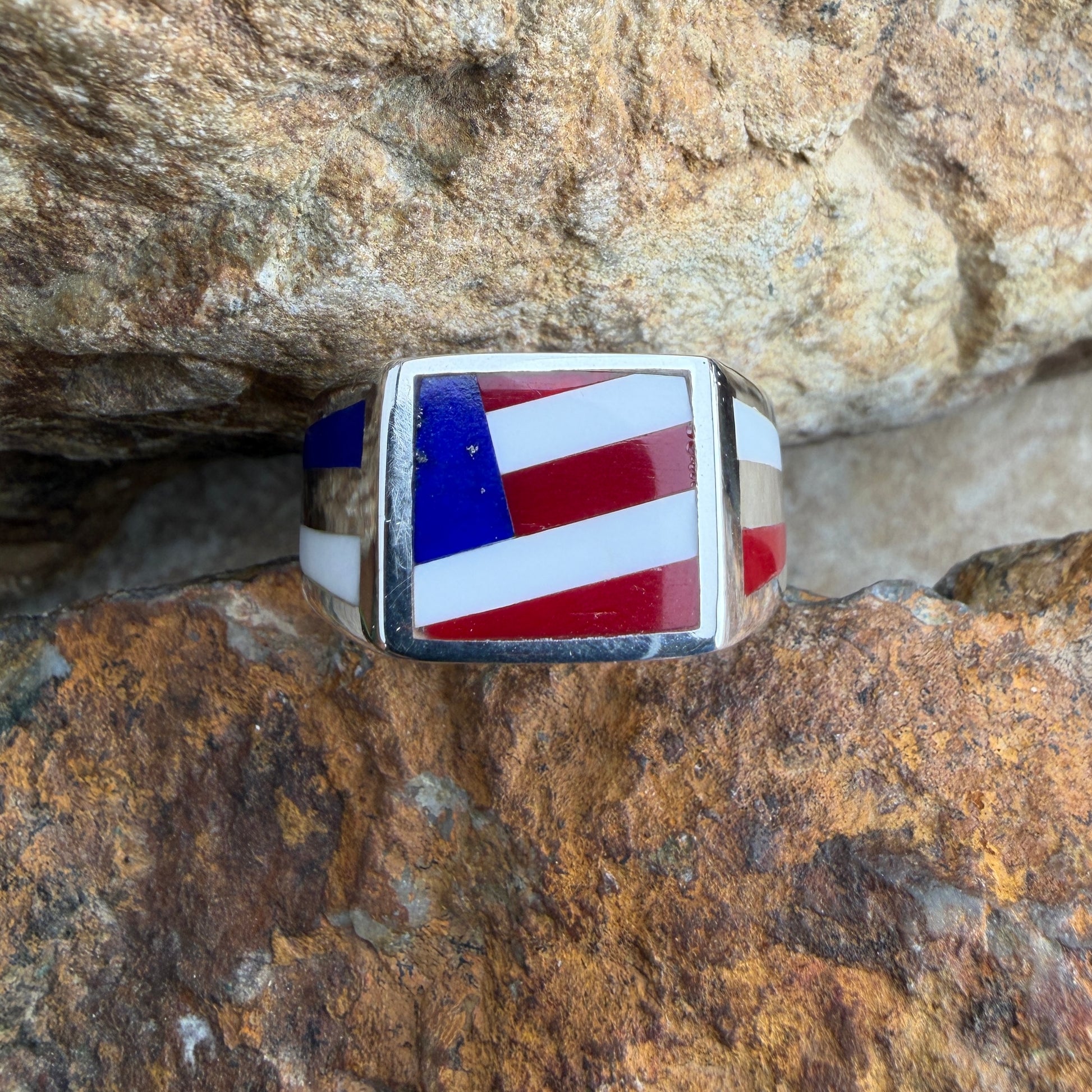 Ring with American flag design, placed on a rocky surface