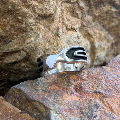 Shank area of a silver ring with black detailing