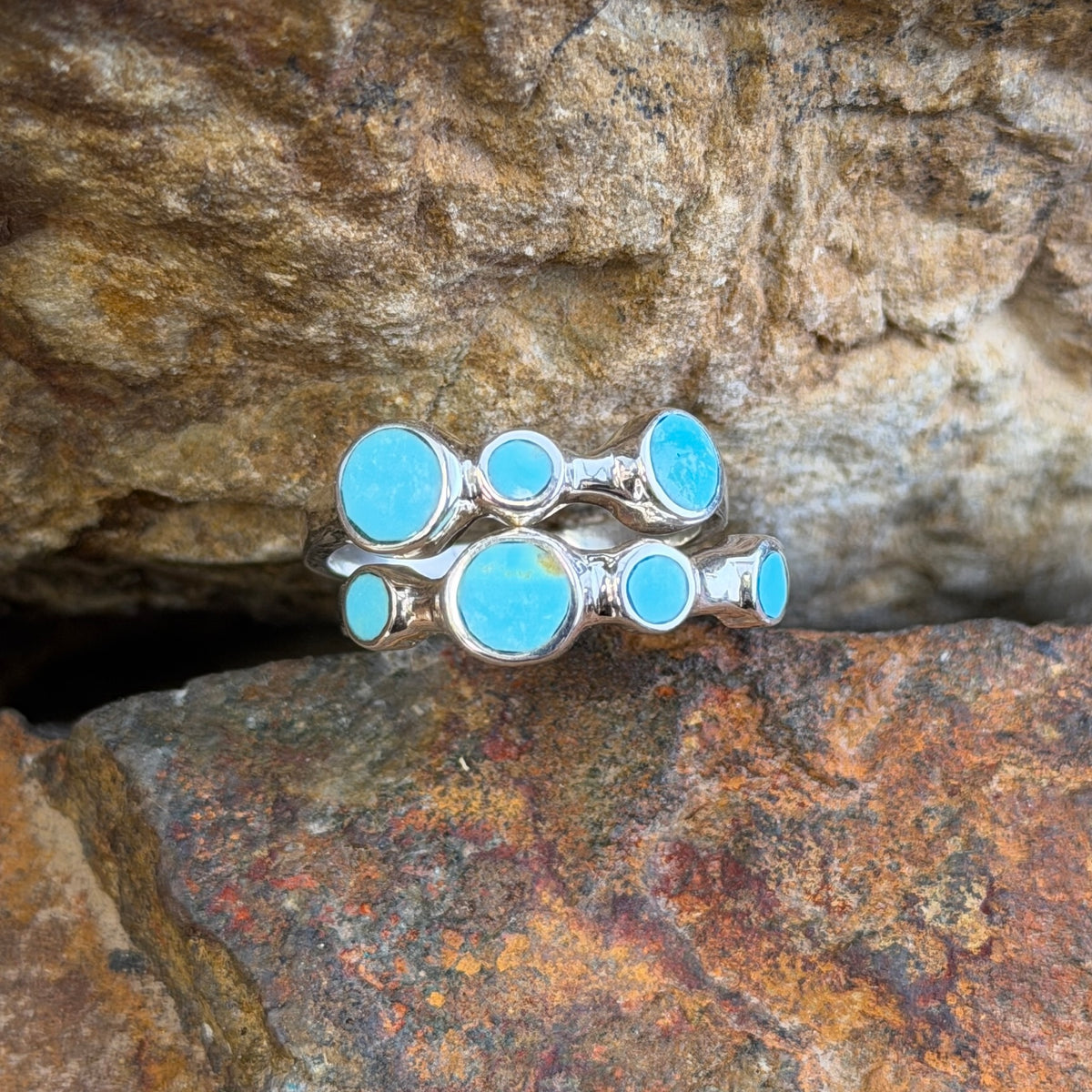 Front view of two sterling silver bands with round blue Kingman turquoise stones