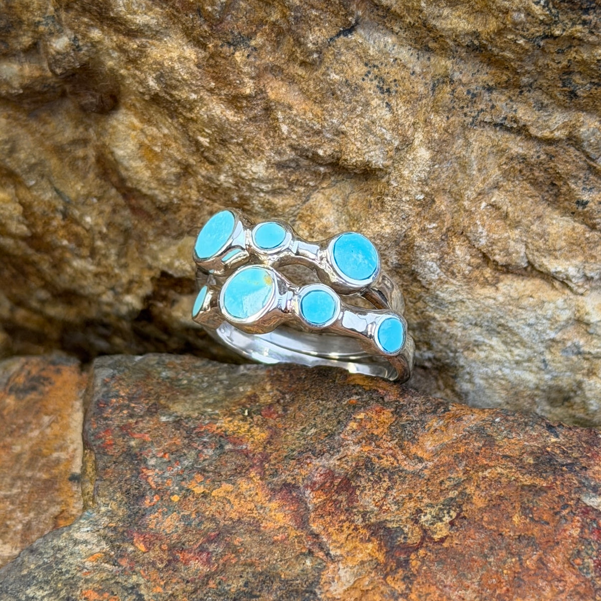 Angled view of David Rosales multi-circle Kingman turquoise ring set
