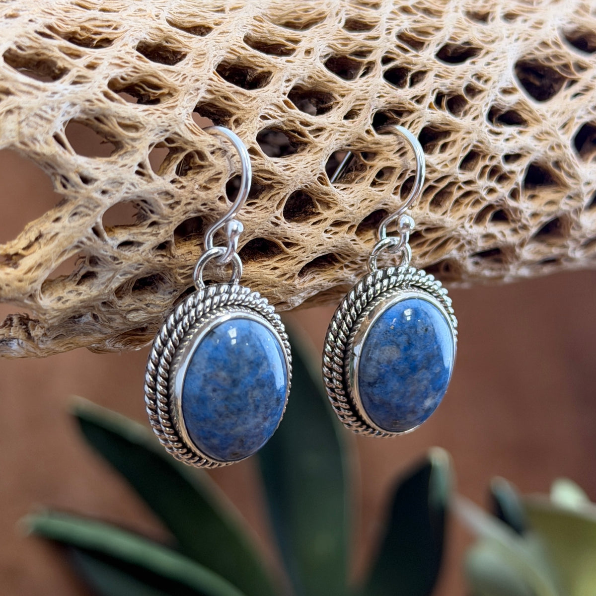 Backs of Artie Yellowhorse sterling silver denim lapis dangle earrings showing the artist hallmark