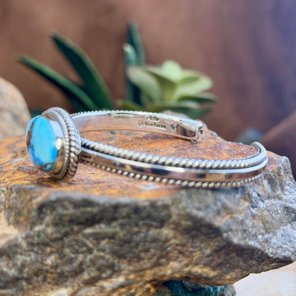 Side view of open cuff with polished silver rails and twisted-rope trim