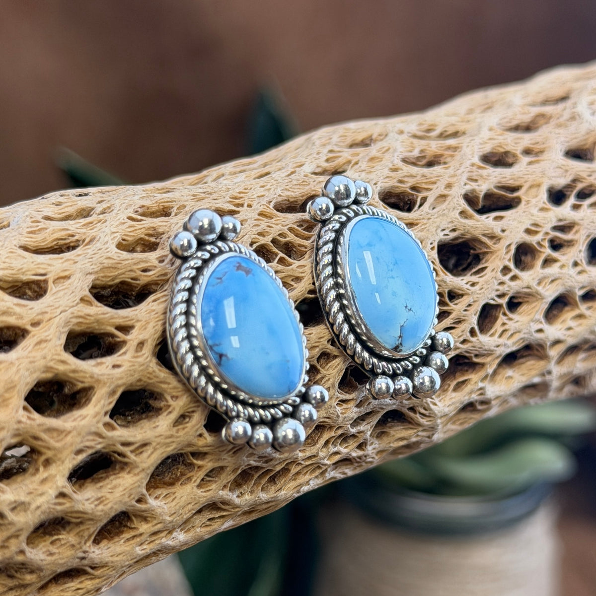 Backs of Artie Yellowhorse sterling silver post earrings showing hallmark and posts