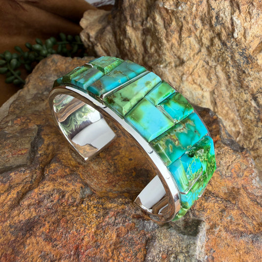 Turquoise mosaic cuff bracelet on a stone surface