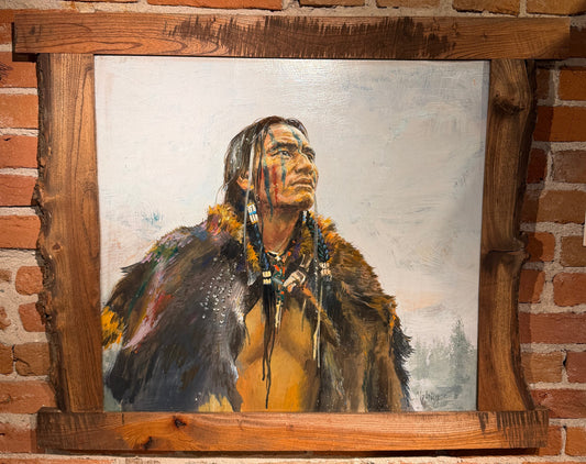 Painting of a Native American figure in a wooden frame against a brick wall.