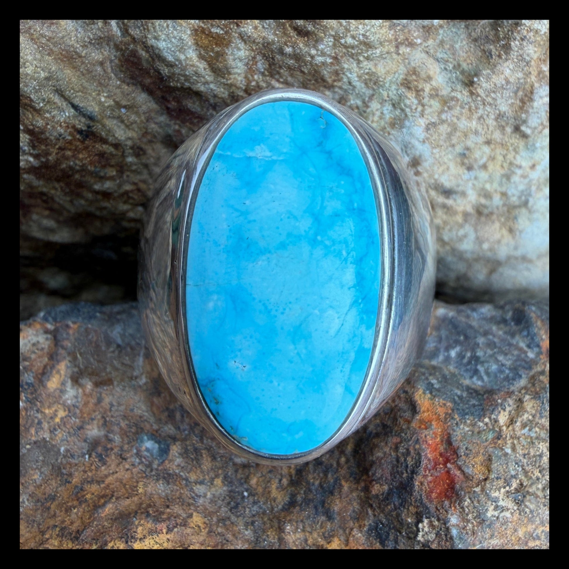 Turquoise stone ring on a rocky surface