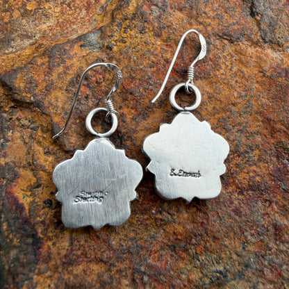 Back of silver floral earrings with stamping on the back. "Sterling" and "E. Enoah"