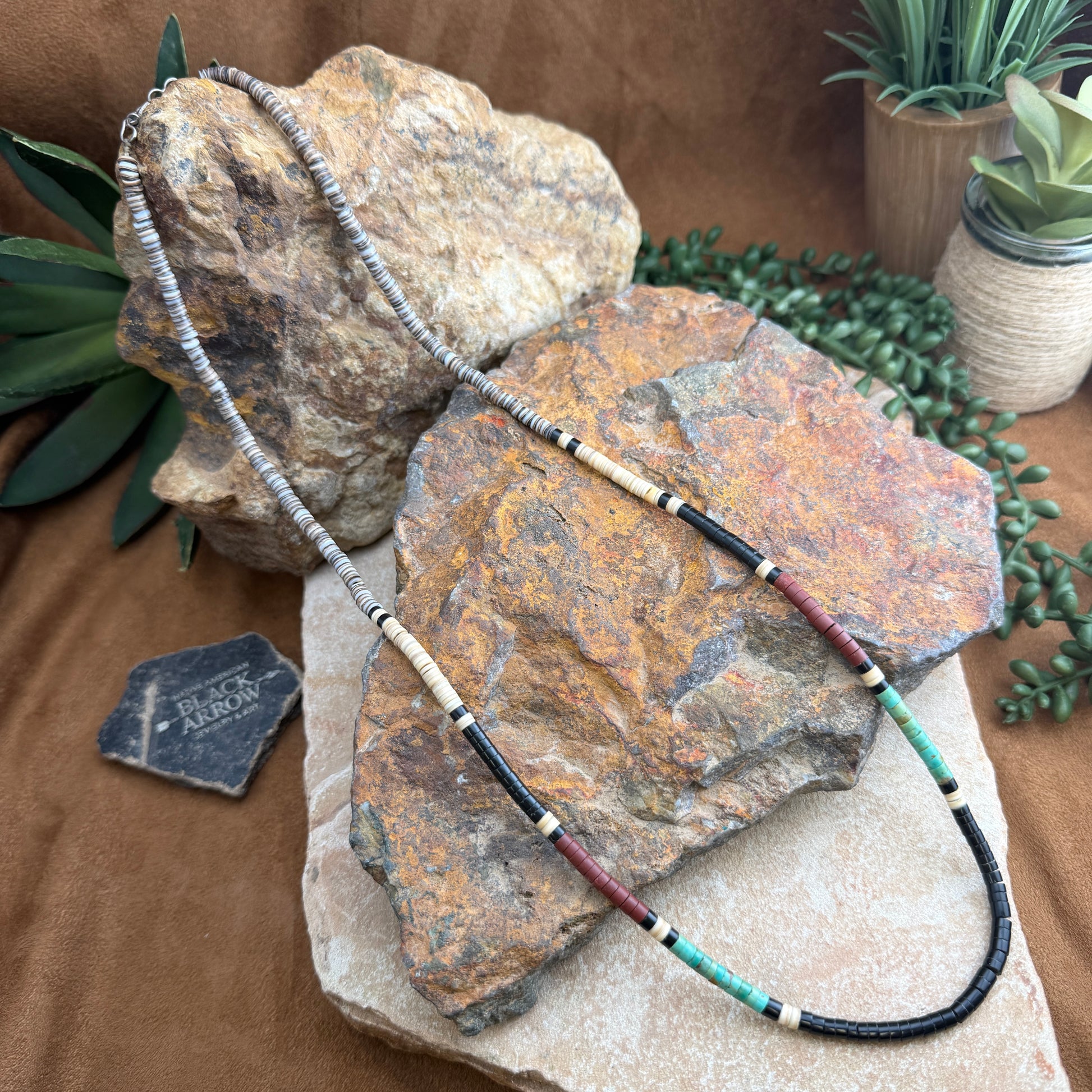 Necklace with beads on a stone surface with plants in the background