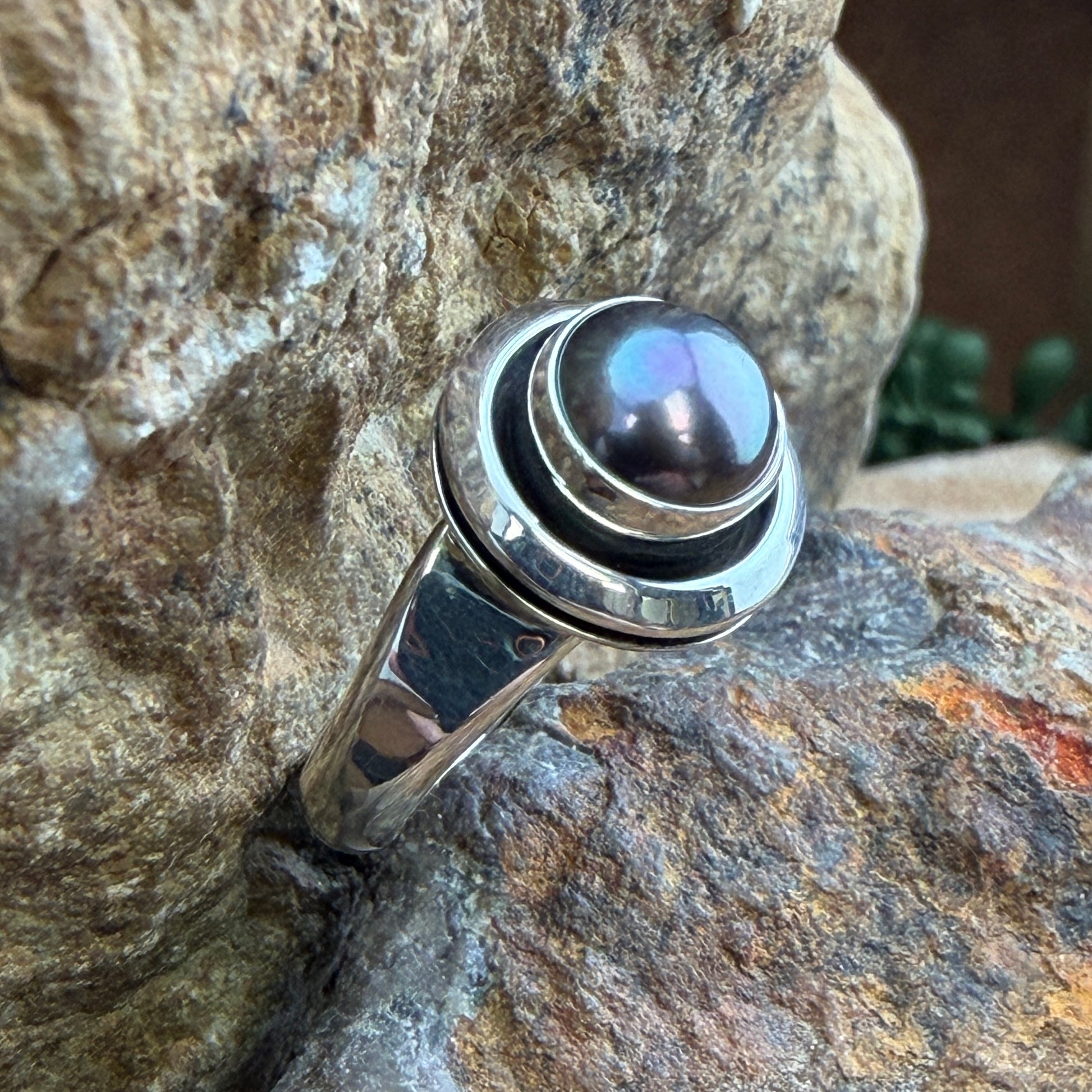 Dark Grey Freshwater Pearl Sterling Silver Ring by Artie Yellowhorse - angled view on rock showing double-rim shadowbox setting and split shank