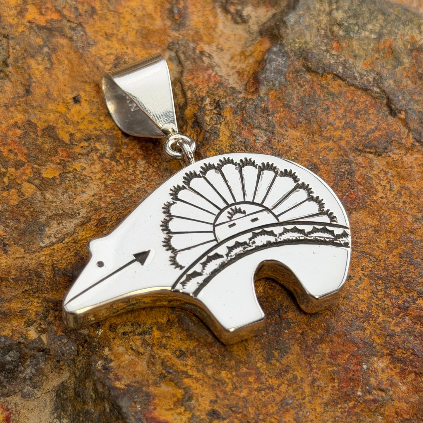 Reversible Sterling Silver Bear Pendant by Norman Woody - side one showing hand-engraved rising sun with radiating rays, mountain range, and heart line arrow