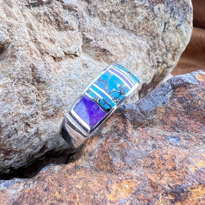 Silver ring with blue and purple stones on a rock
