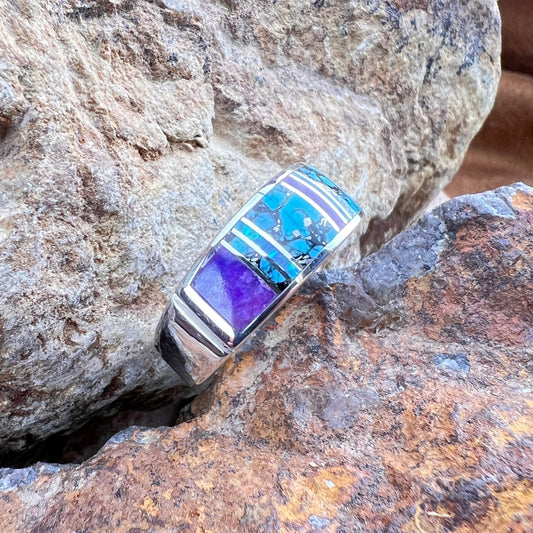 Silver ring with blue and purple stones on a rock
